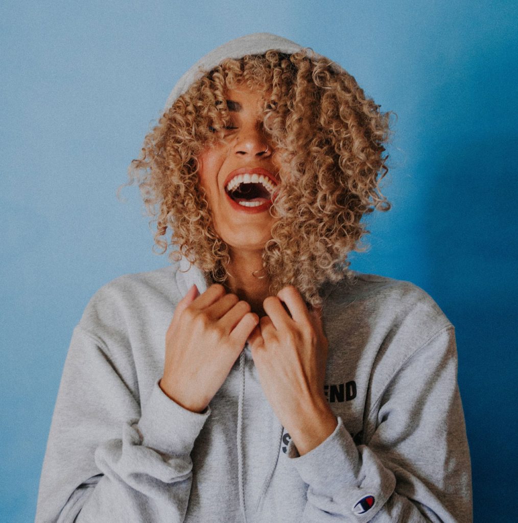 A woman smiling, representing confidence and well-being through holistic health support.