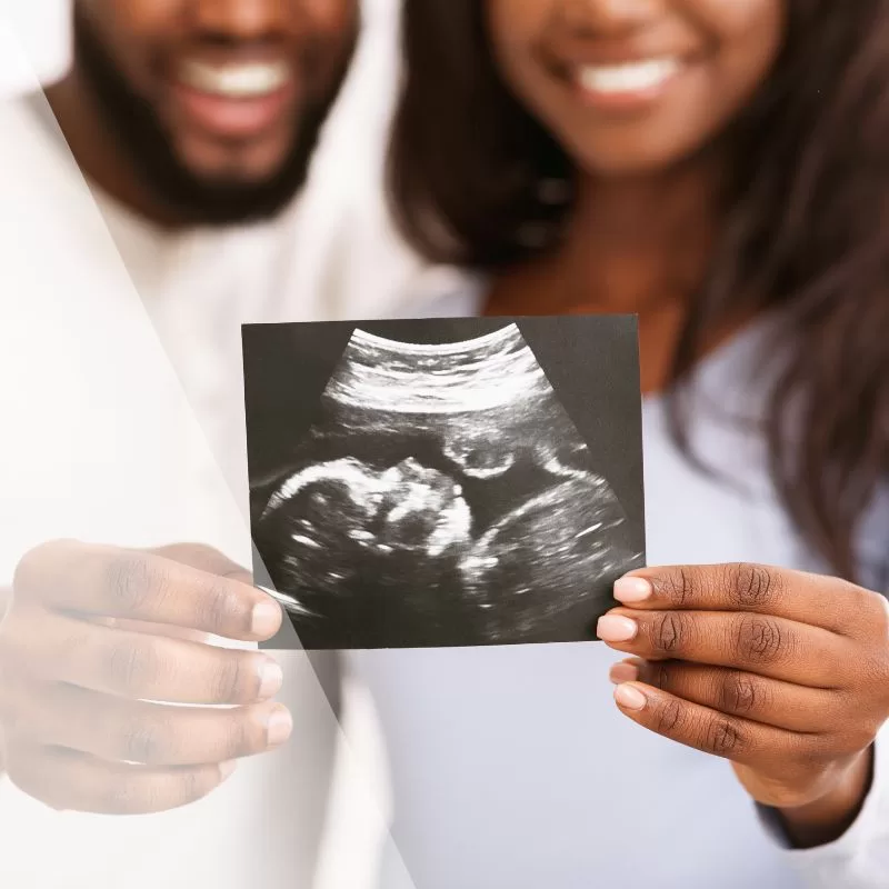 Couple holding an ultrasound photo, symbolizing hope and excitement for their future baby.