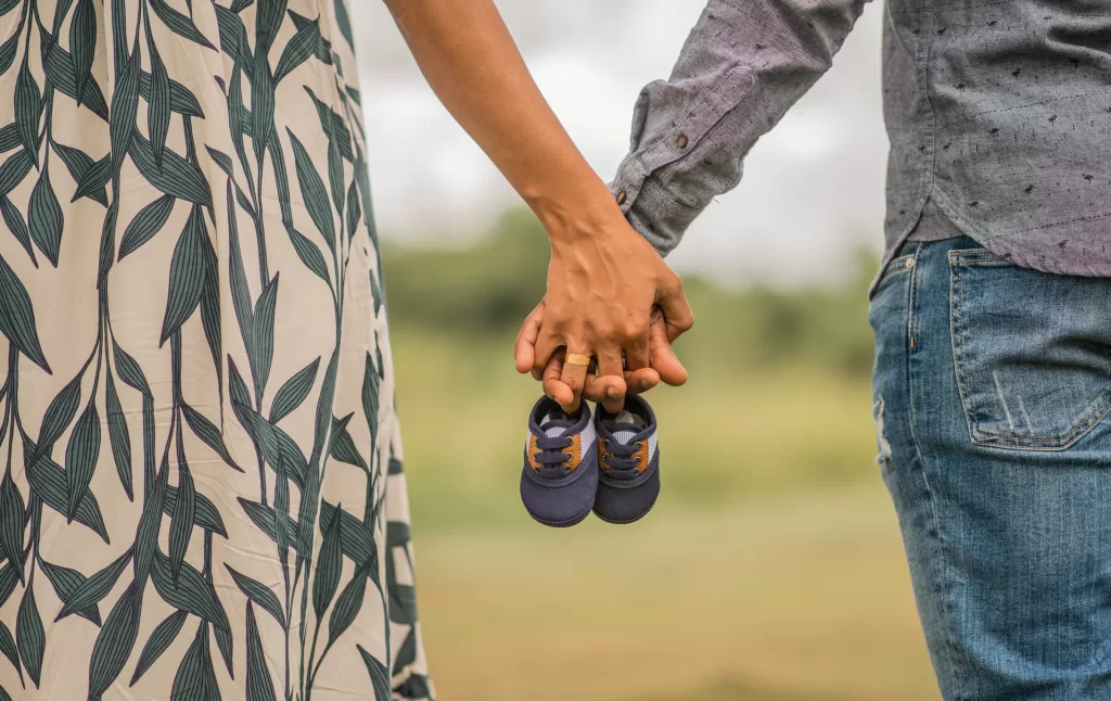 A couple holding baby shoes, symbolizing hope and anticipation for the arrival of their baby.