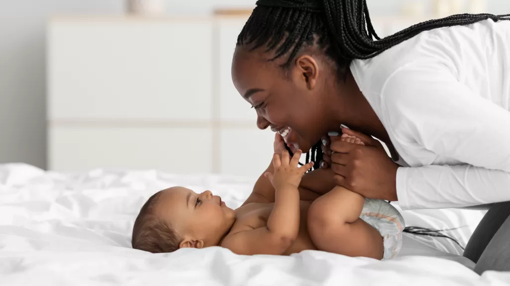 A mom smiling at her baby, symbolizing the benefits of holistic healing and natural medicine for long-term health and wellness.