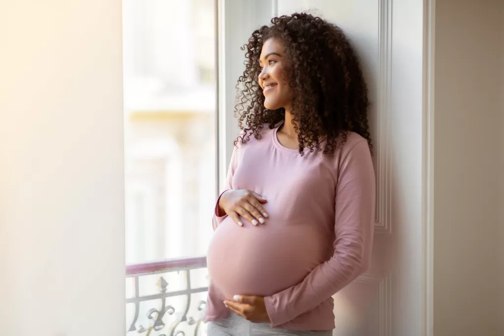 Pregnant woman holding her belly, representing holistic pregnancy and postpartum care