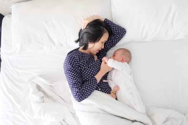 Mother holding newborn baby at Awaken and Bloom holistic health clinic in Salt Lake City