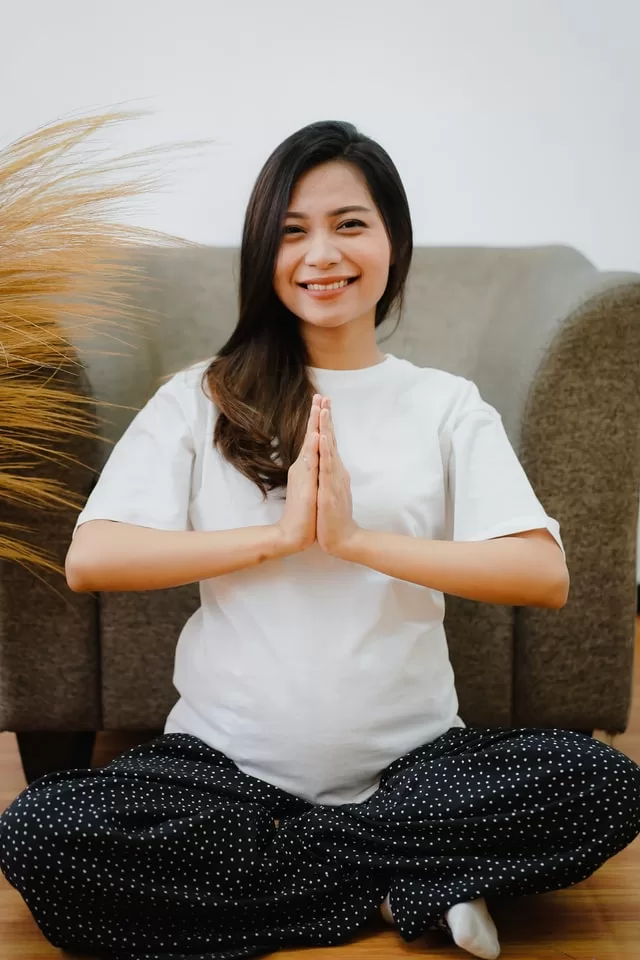 Pregnant woman meditating as part of holistic prenatal care at Awaken and Bloom in Salt Lake City