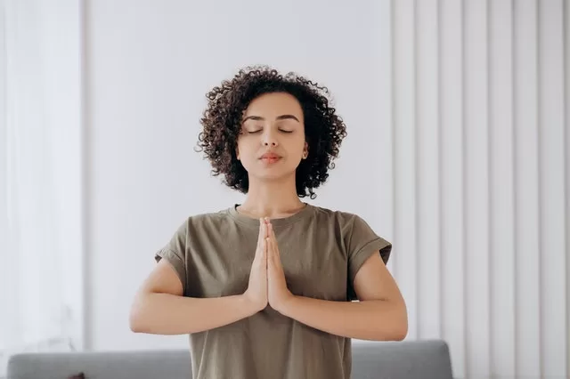 Woman practicing meditation in a serene environment, promoting stress relief and holistic wellness.