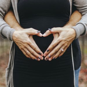 couple holding woman's pregnant belly
